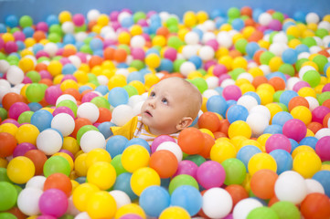 Fototapeta na wymiar Малыш в бассейне с цветными шариками