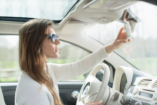 Beautiful Young Woman In Her Car Looking In The Mirror