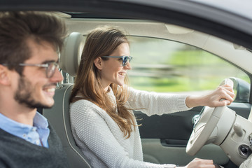 Young couple driving a car on a country road