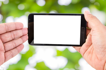 Man hand hold blank touch screen smart phone on Soft green natur