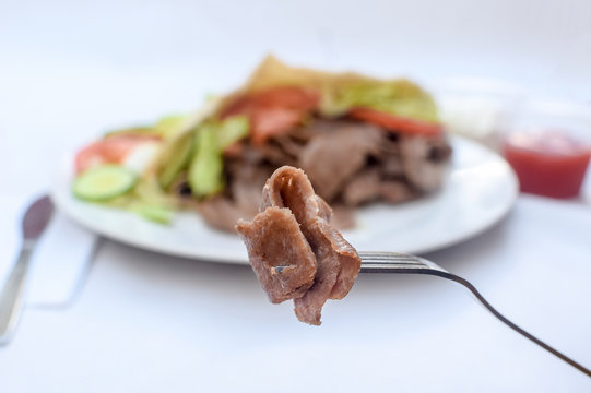 Doner meat kebab in a fork in focus