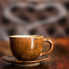 Coffee cup with smoke is heart shape for text on table in cafe.