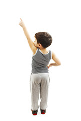 Back view of little boy points at wall. Rear view. Isolated on white background 