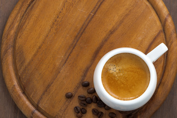 cup of fresh espresso on a wooden tray, top view, horizontal