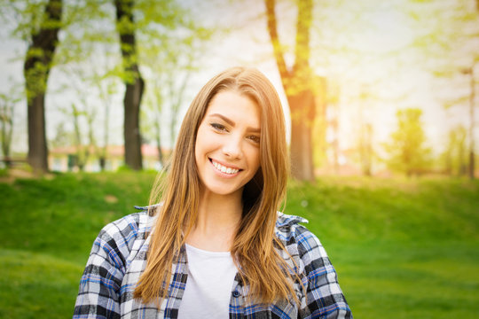 Beautiful teenage girl in park in autumn smiling