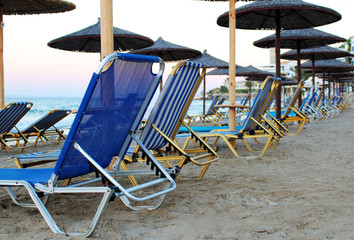 Sandy beach with many loungers and parasols - obrazy, fototapety, plakaty