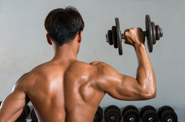 Fototapeta na wymiar Muscle athlete man in gym making elevations. Bodybuilder trainin