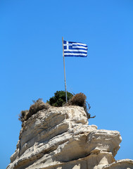 Greece flag on the cliff at the sea