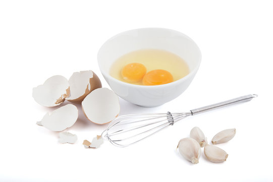 Isolated of Eggs in a Bowl with garlics and Whisk