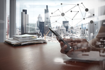 double exposure of businessman hand use smart phone with office