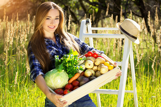 Счастливая молодая девушка с овощами в ящике 