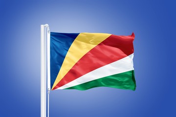 Flag of Seychelles flying against a blue sky