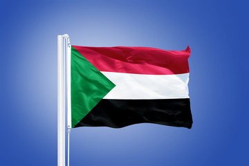 Flag of Sudan flying against a blue sky