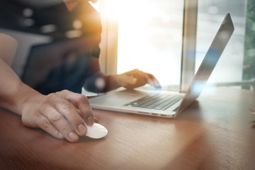 close up of business man hand working on laptop computer on wood