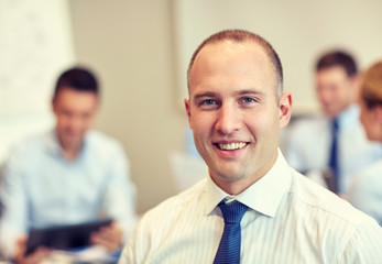 group of smiling businesspeople meeting in office