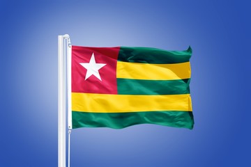 Fototapeta na wymiar Flag of Togo flying against a blue sky