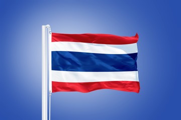 Flag of Thailand flying against a blue sky