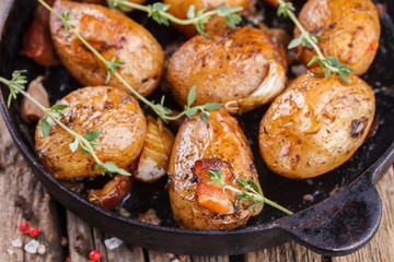 Young potatoes fried in a pan. With garlic, pancetta and thyme.selective focus