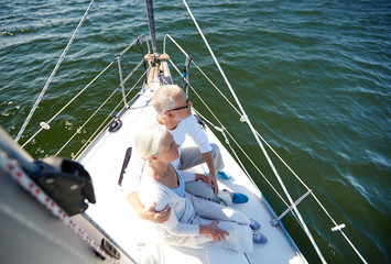 senior couple hugging on sail boat or yacht in sea