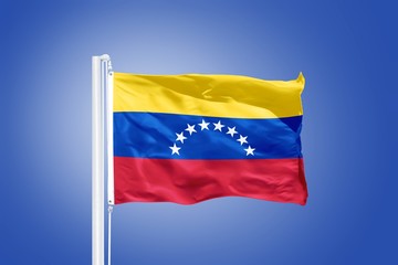 Flag of Venezuela flying against a blue sky