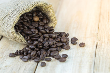 coffee beans in sack bag on wooden background