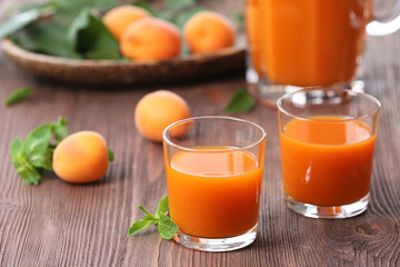 Obraz na płótnie Canvas Glasses of apricots juice on wooden table, closeup