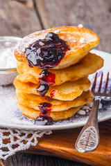 Stack of pancakes with jam and sugar