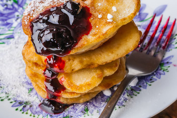Stack of pancakes with jam and sugar