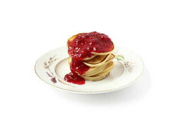 Hot fritters with sweet raspbery jam on a small white plate