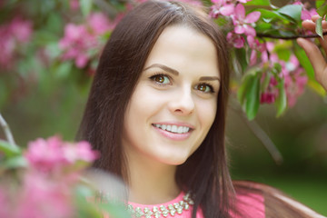 Fototapeta premium Young spring fashion woman. Trendy girl in the flowering trees i