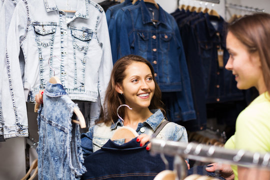 Two girls buying vest in a store
