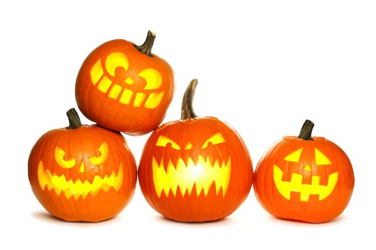 Group of fun lit Halloween Jack o Lanterns isolated on a white background