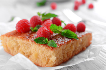 Fresh pie with raspberry on parchment on wooden table, closeup