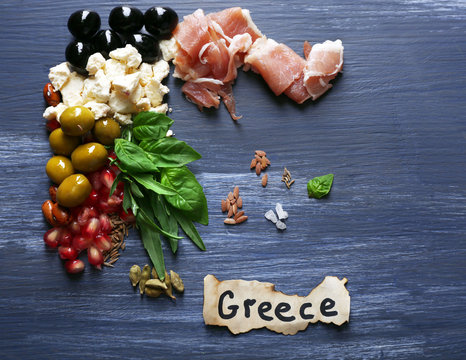 Map of Greece made with ingredients of traditional Greek cuisine on color wooden background