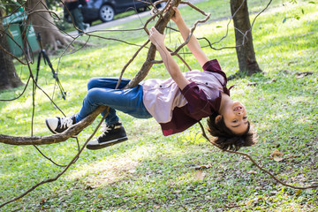 Little boy climb on a tree rope