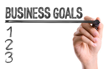 Hand with marker writing the word Business Goals