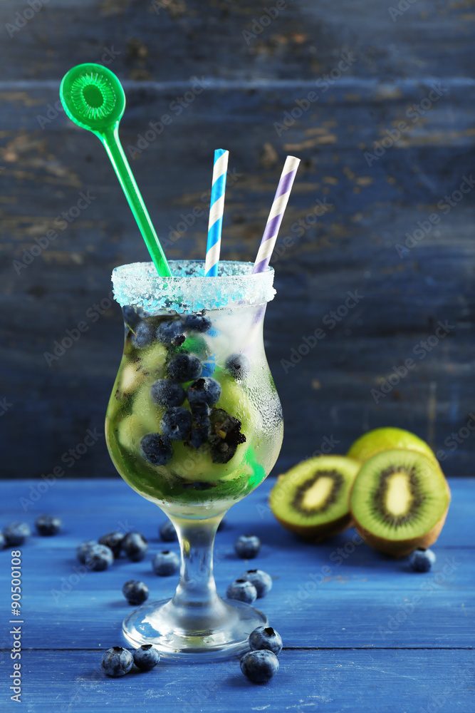 Sticker kiwi and blueberry cocktail on color wooden background