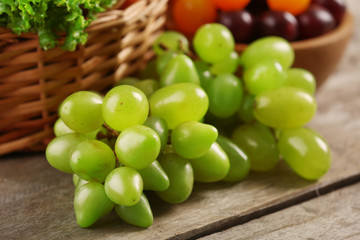 Heap of fresh fruits and vegetables in basket on wooden table close up