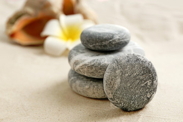 Naklejka na ściany i meble Stack of spa stones on sand background