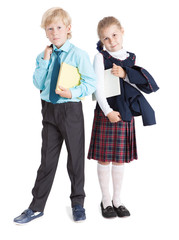 Two pretty pupils in school uniform stand full-length with books in hands, isolated on white background