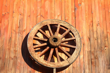 Obraz premium Wooden wheel hanging on the wall