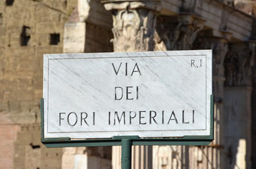 Obraz premium Via dei Fori Imperiali signal with Forum of Augustus in the background 