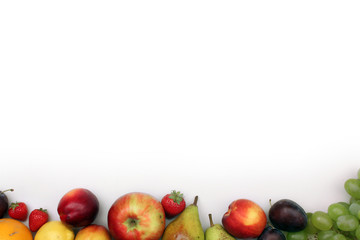 Fresh fruits border on white background with copyspace