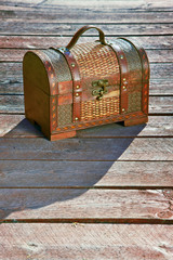 Old lonely chest on wooden boards