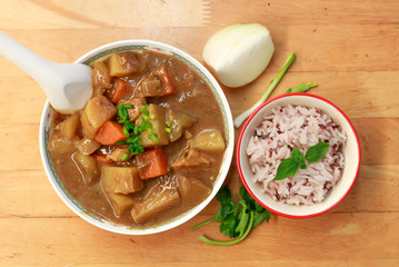 Curry pork japanese style with rice on the wood background.