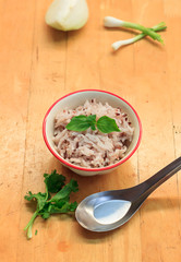 Rice in the bowl and  blur onion on wood background.