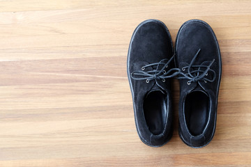 Black leather shoes on wood shelf background