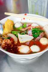 Yen ta four noodle style thai with drinking water on the table.