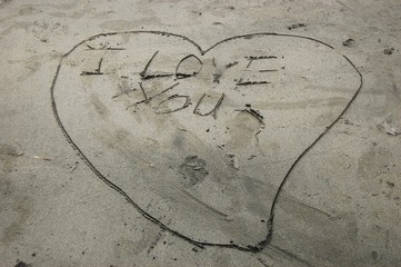 Fototapeta na wymiar I love you and heart sign written on the sand beach photo image