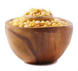 Split dried yellow peas on wood cup isolated on white background